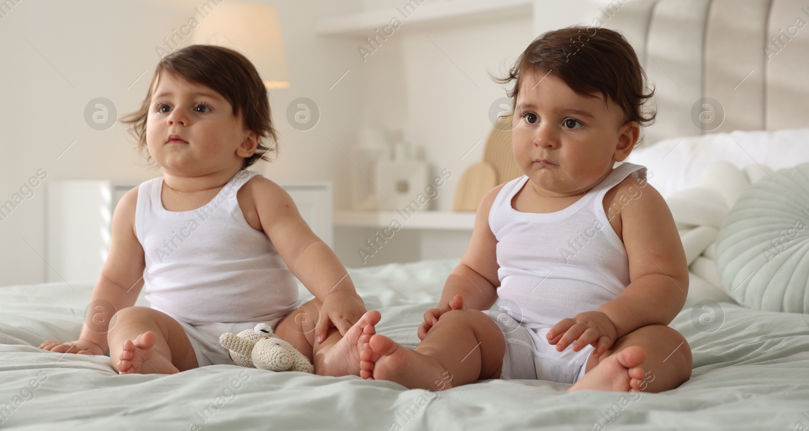 Cute little twin babies on bed at home Photo of Cute little twin babies on bed at home