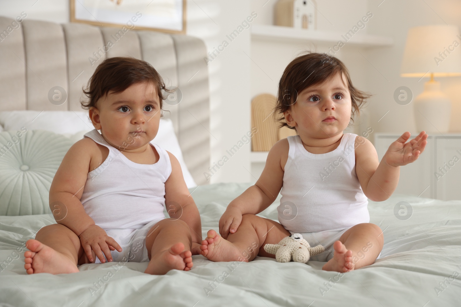 Cute little twin babies on bed at home Photo of Cute little twin babies on bed at home