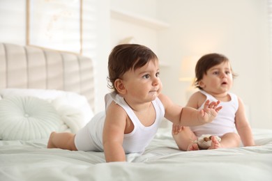 Photo of Cute little twin babies on bed at home, selective focus