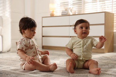 Photo of Cute little twin babies on floor at home