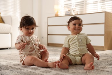 Photo of Cute little twin babies on floor at home