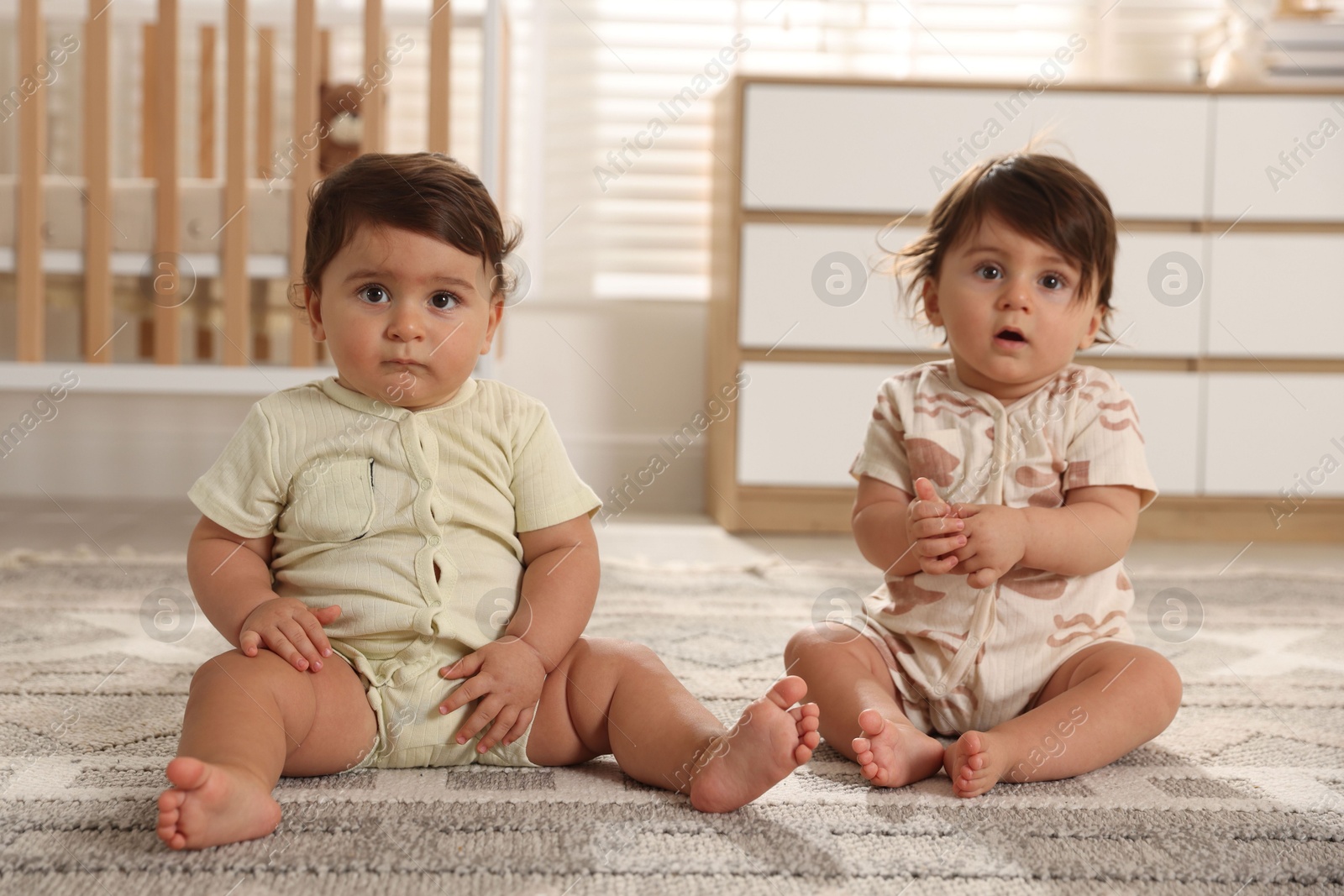 Cute little twin babies on floor at home Photo of Cute little twin babies on floor at home
