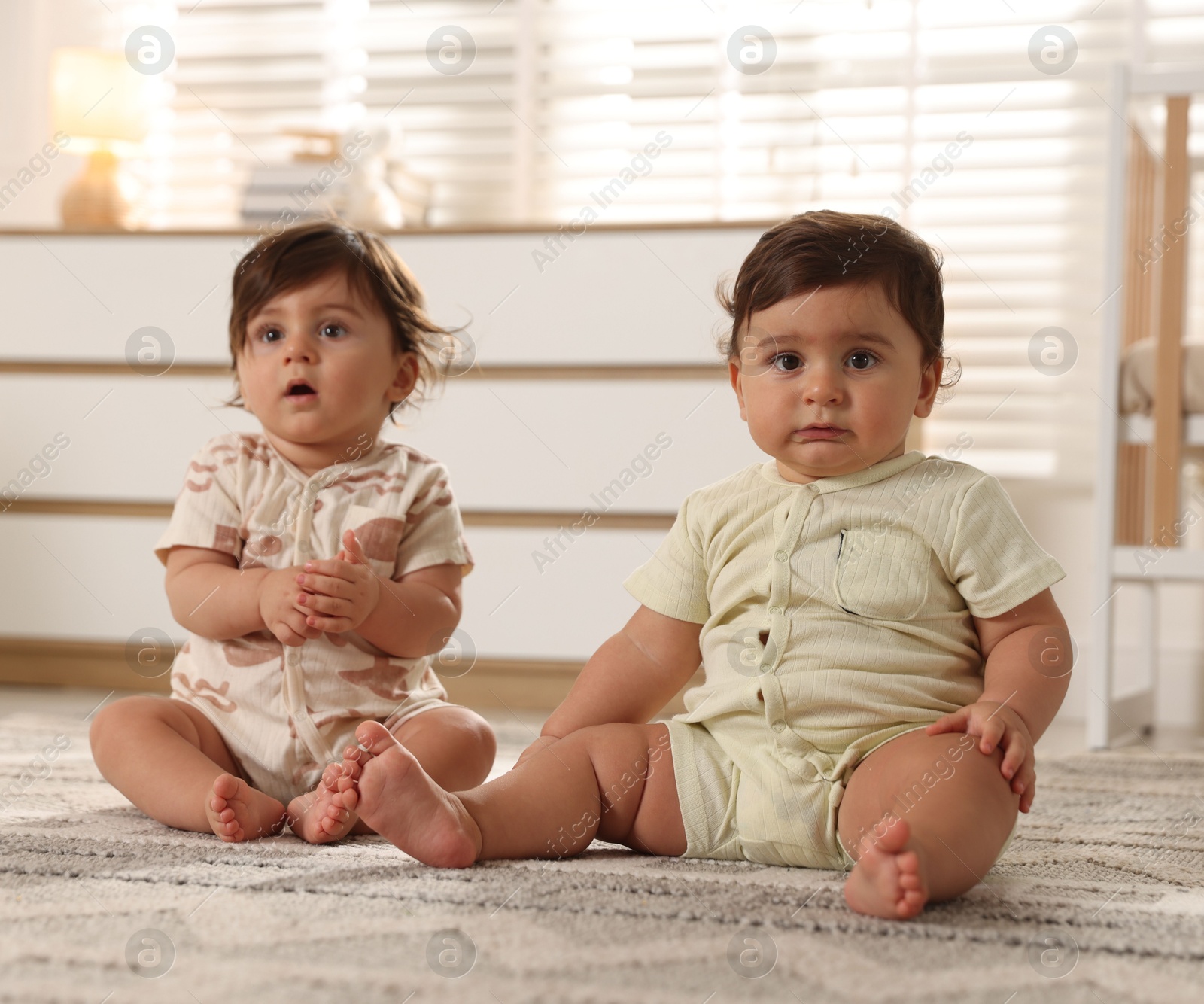 Cute little twin babies on floor at home Photo of Cute little twin babies on floor at home