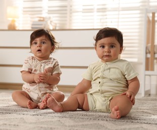 Photo of Cute little twin babies on floor at home