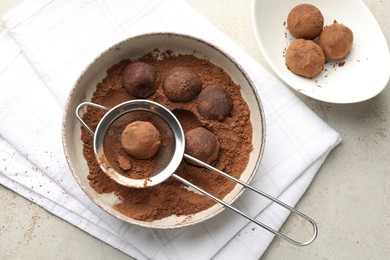 Photo of Making tasty chocolate candies with cocoa powder at light table, flat lay