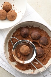 Photo of Making tasty chocolate candies with cocoa powder at light table, flat lay