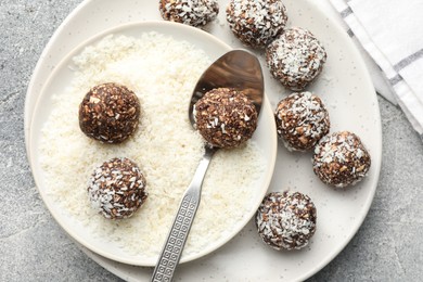 Photo of Making tasty chocolate candies with coconut flakes at grey table, top view
