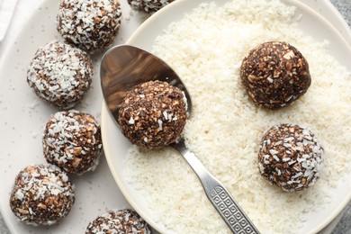 Photo of Making tasty chocolate candies with coconut flakes at table, top view