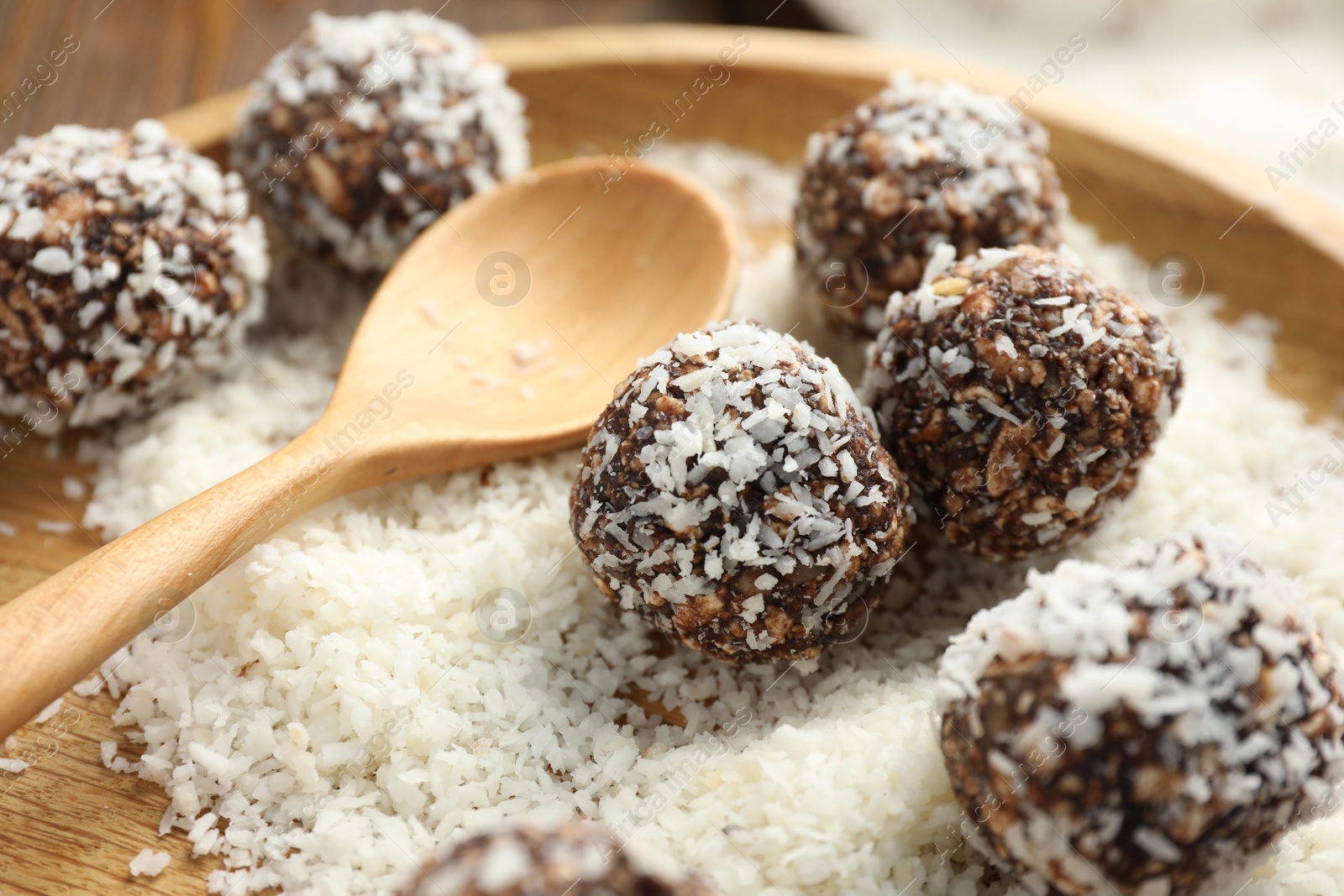 Tasty chocolate candies with nuts and coconut flakes on table, closeup Photo of Tasty chocolate candies with nuts and coconut flakes on table, closeup