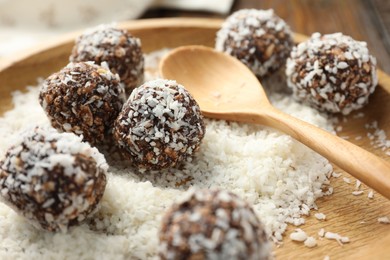 Photo of Tasty chocolate candies with nuts and coconut flakes on table, closeup