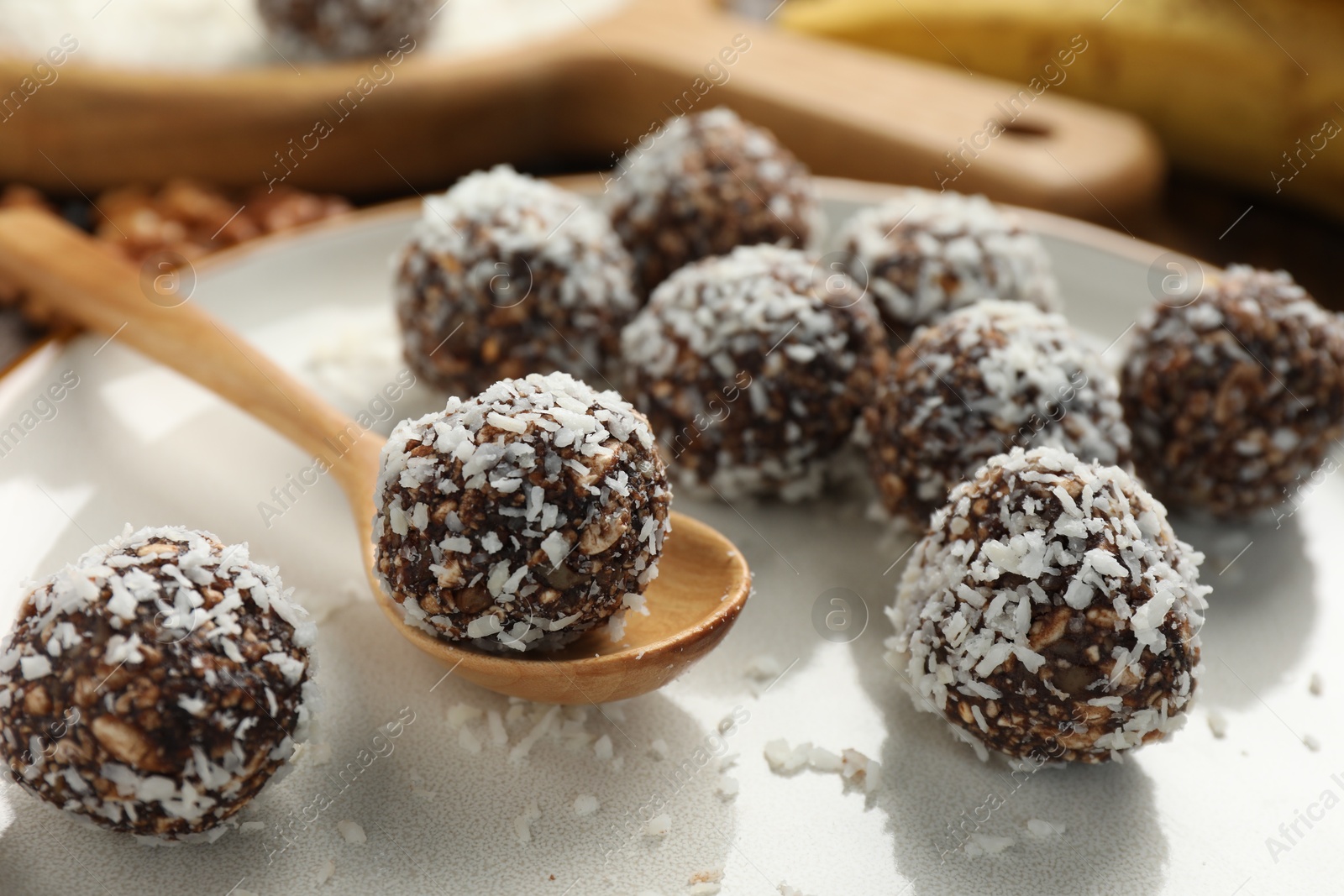 Tasty chocolate candies with nuts and coconut flakes on table, closeup Photo of Tasty chocolate candies with nuts and coconut flakes on table, closeup
