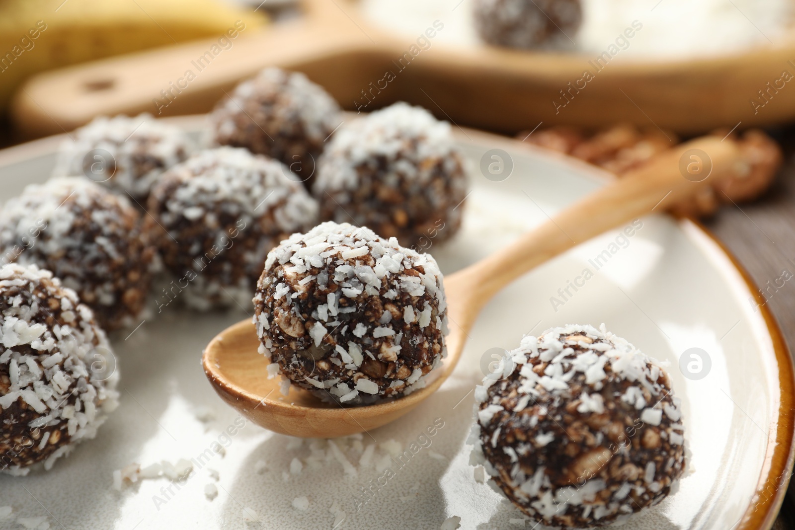 Tasty chocolate candies with nuts and coconut flakes on table, closeup Photo of Tasty chocolate candies with nuts and coconut flakes on table, closeup
