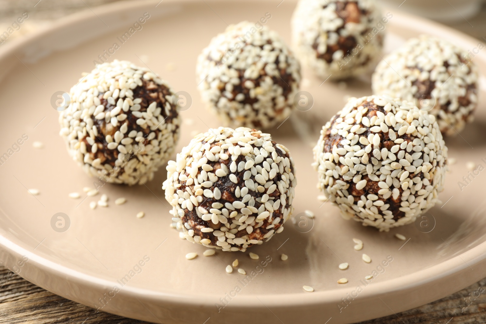 Tasty chocolate candies with nuts and sesame seeds on table, closeup Photo of Tasty chocolate candies with nuts and sesame seeds on table, closeup
