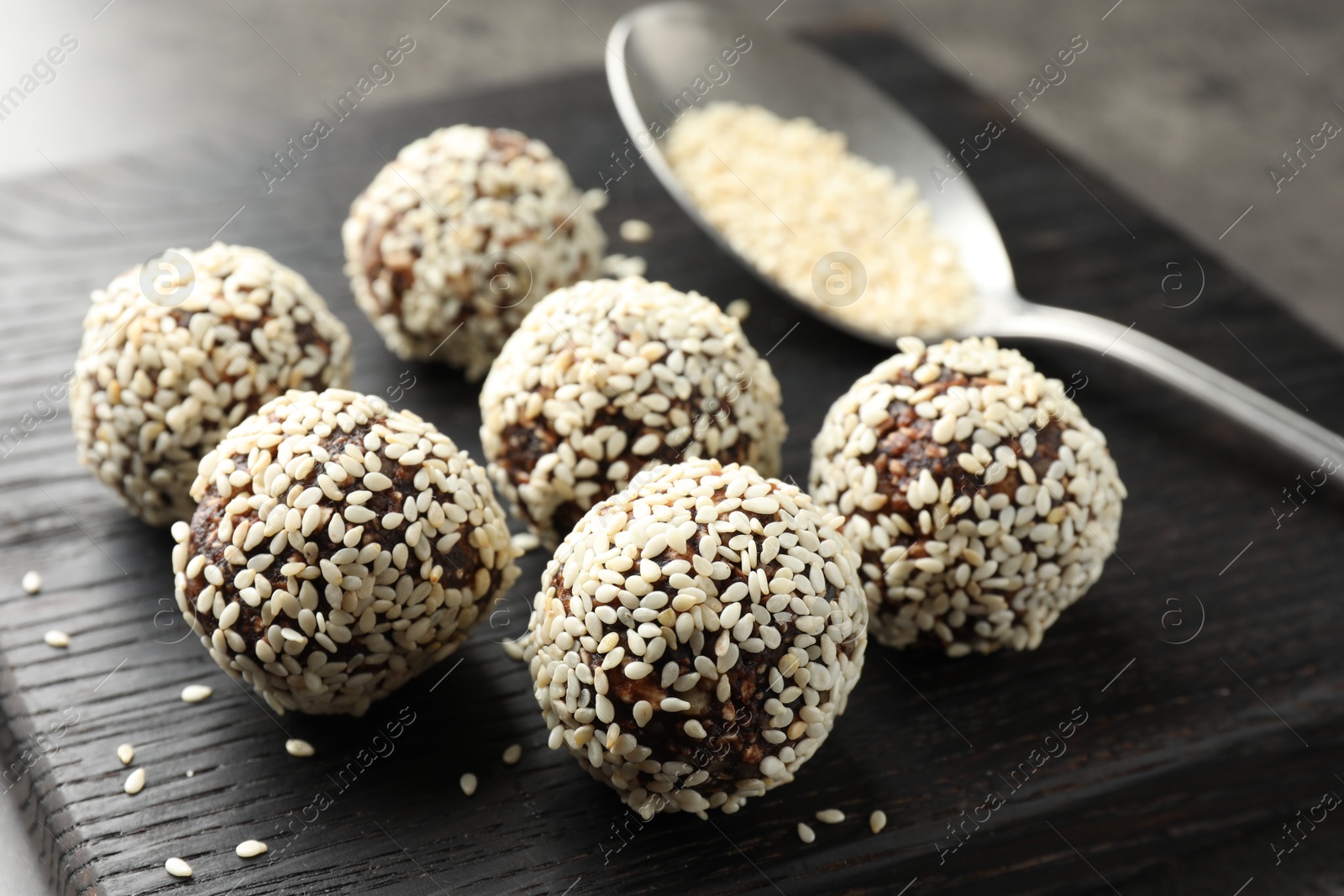 Tasty chocolate candies with nuts and sesame seeds on table, closeup Photo of Tasty chocolate candies with nuts and sesame seeds on table, closeup