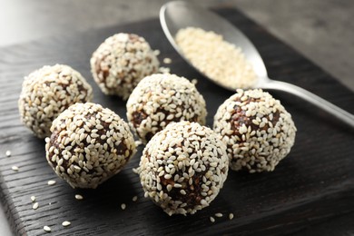 Photo of Tasty chocolate candies with nuts and sesame seeds on table, closeup