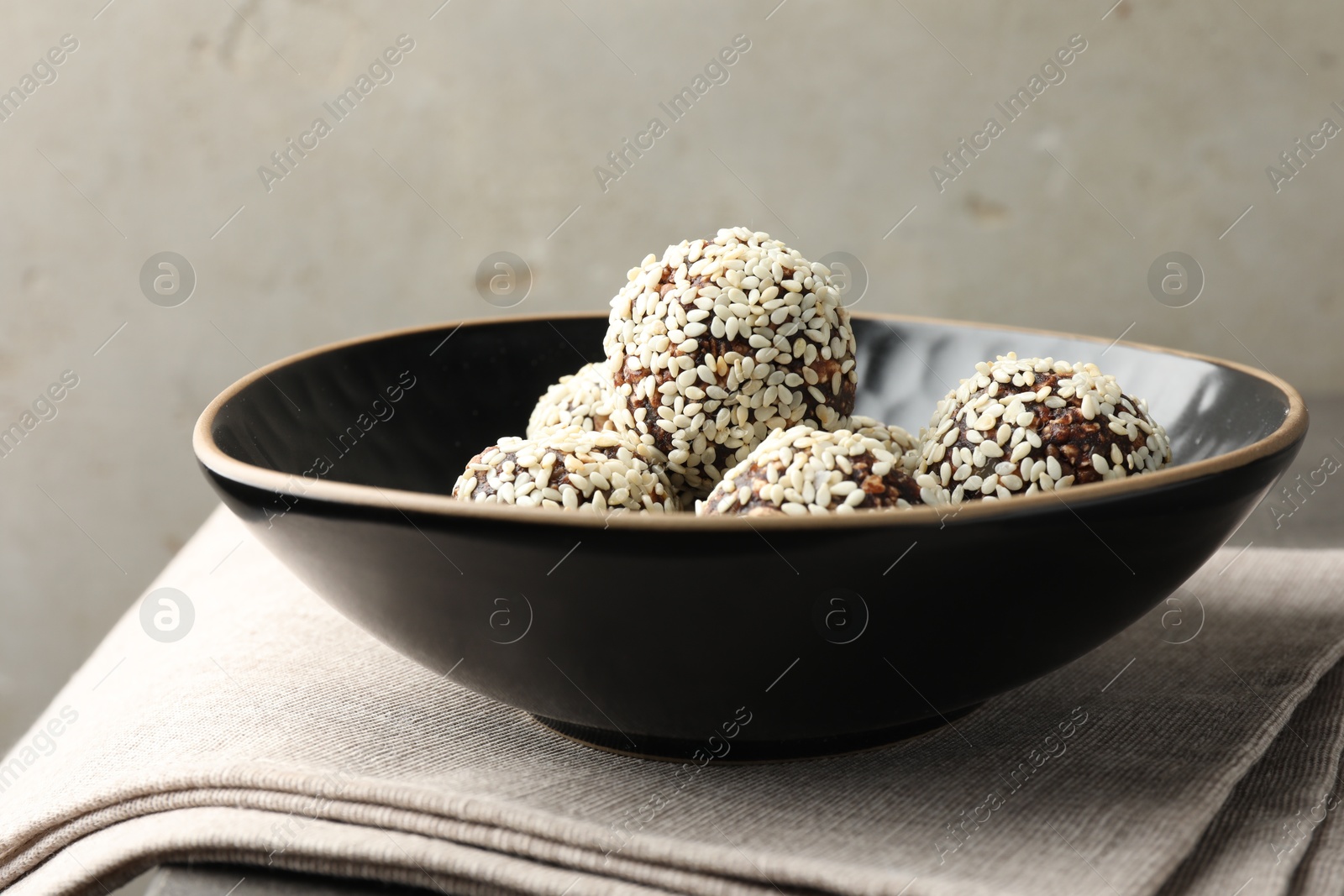 Tasty chocolate candies with nuts and sesame seeds on table, closeup Photo of Tasty chocolate candies with nuts and sesame seeds on table, closeup