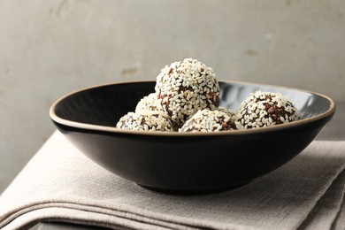 Photo of Tasty chocolate candies with nuts and sesame seeds on table, closeup