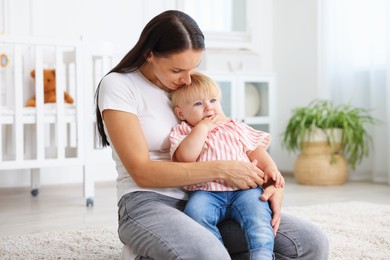 Photo of Mother with cute little baby on floor in room