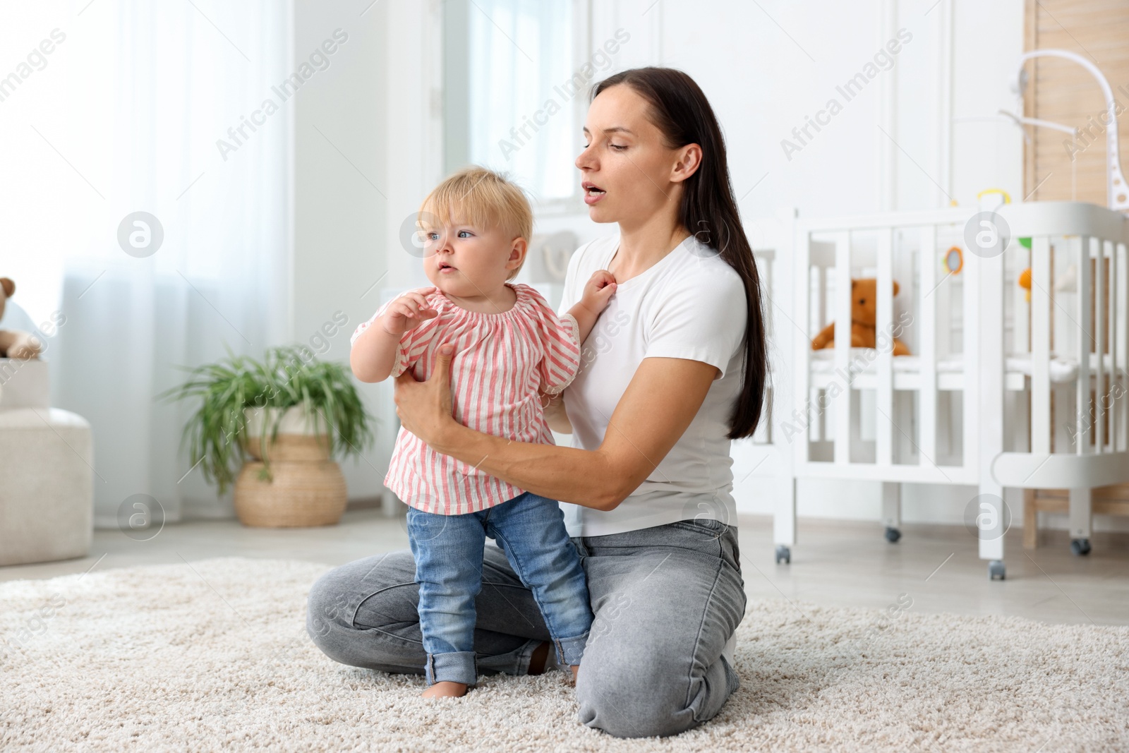Mother with cute little baby on floor in room Photo of Mother with cute little baby on floor in room