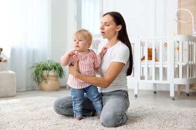 Photo of Mother with cute little baby on floor in room