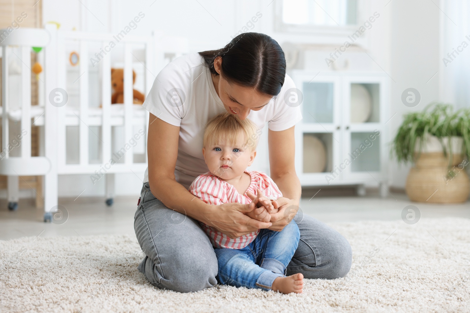 Mother with cute little baby on floor in room Photo of Mother with cute little baby on floor in room
