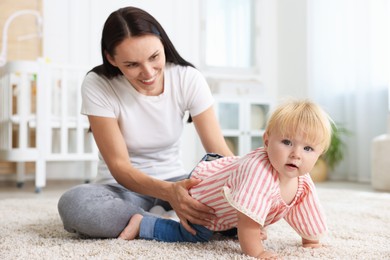 Photo of Mother with cute little baby on floor in room