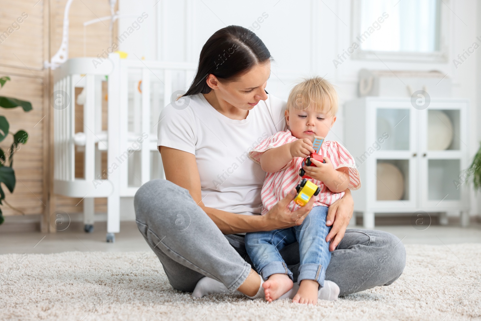 Mother with cute little baby on floor in room Photo of Mother with cute little baby on floor in room