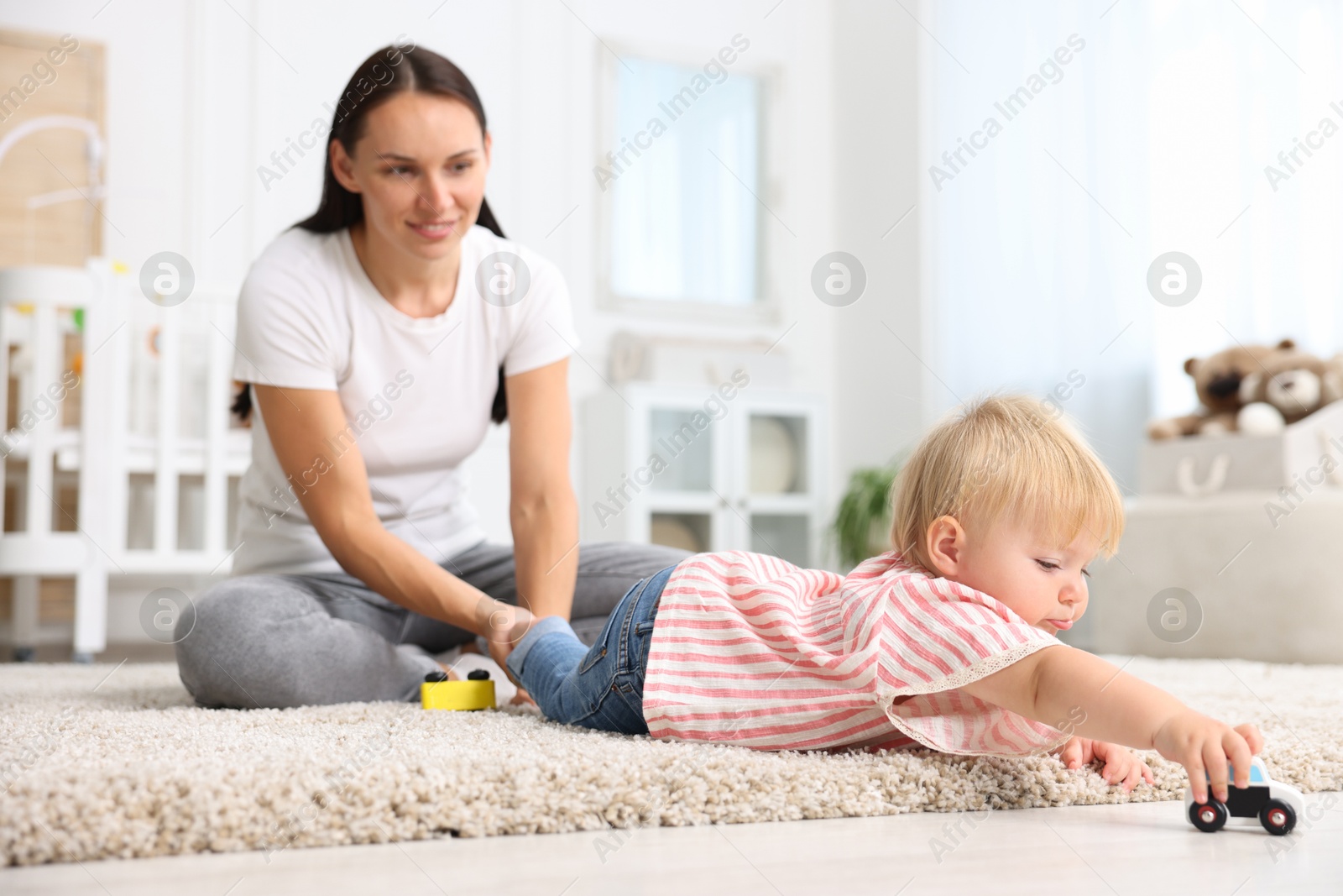 Mother with cute little baby on floor in room Photo of Mother with cute little baby on floor in room