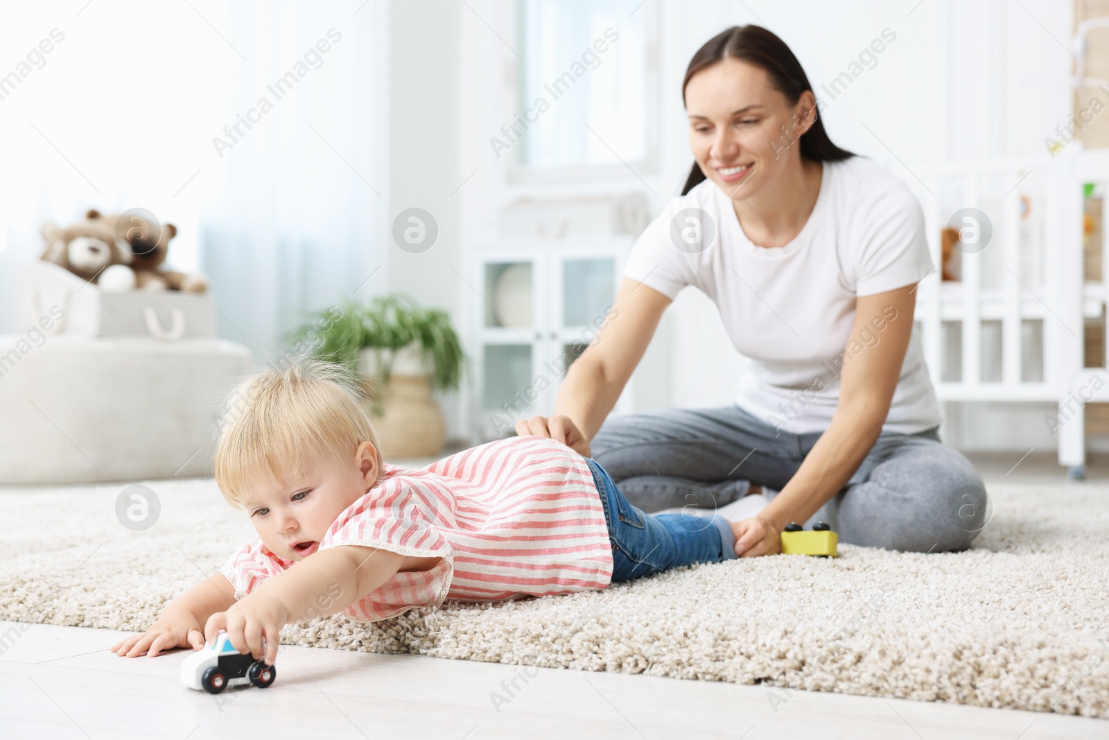 Mother with cute little baby on floor in room Photo of Mother with cute little baby on floor in room