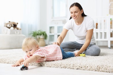 Photo of Mother with cute little baby on floor in room
