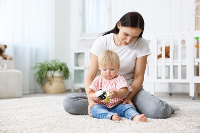 Photo of Mother with cute little baby on floor in room, space for text