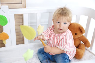 Photo of Cute little baby in crib in room