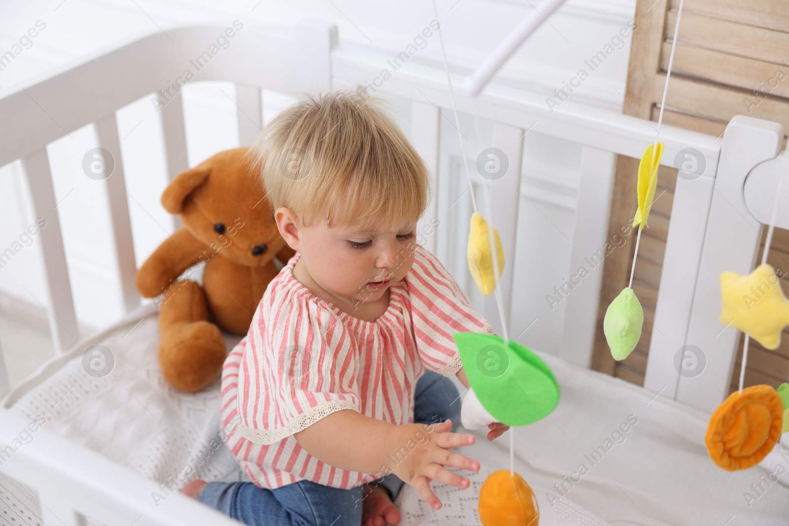 Cute little baby in crib in room Photo of Cute little baby in crib in room