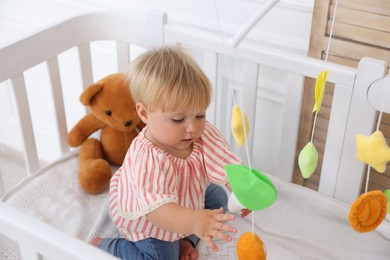 Photo of Cute little baby in crib in room