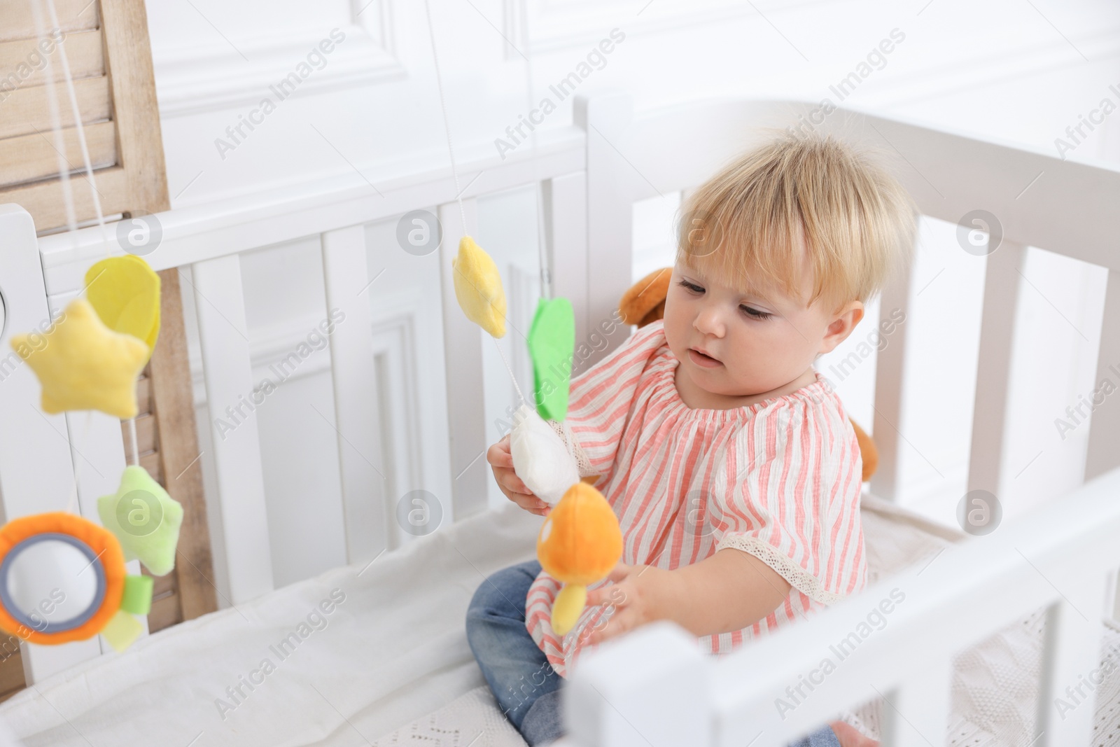 Cute little baby in crib in room Photo of Cute little baby in crib in room