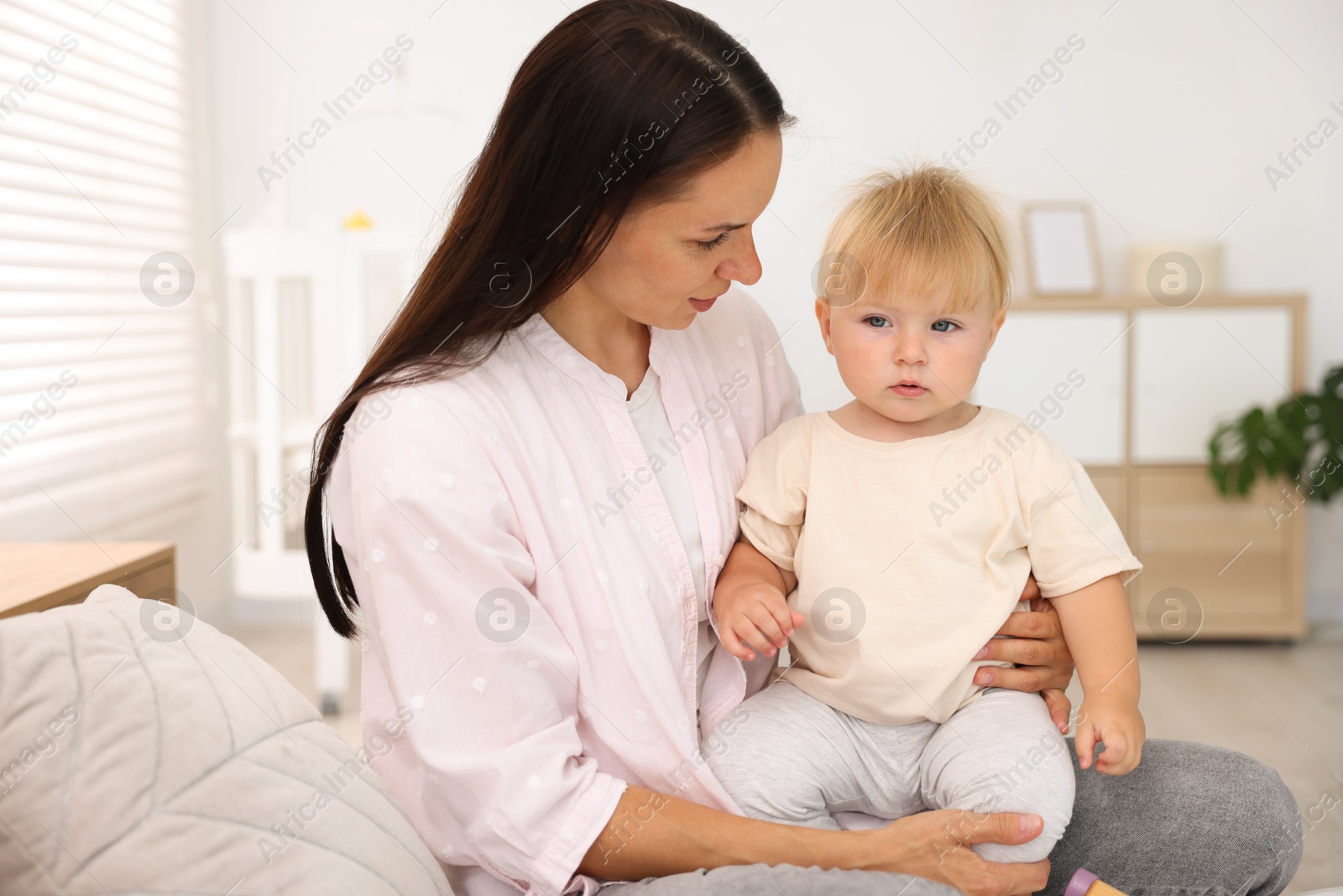 Mother with her cute little baby on bed in room Photo of Mother with her cute little baby on bed in room