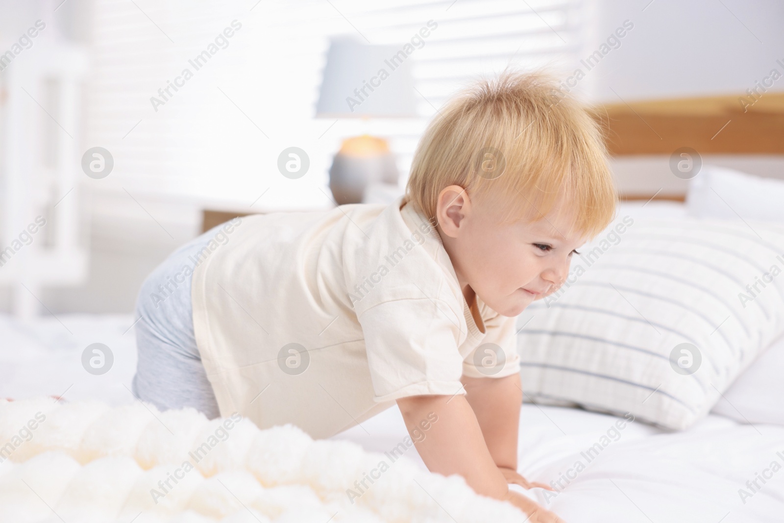 Cute little baby on bed in room Photo of Cute little baby on bed in room