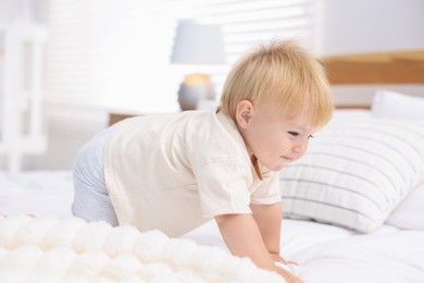 Photo of Cute little baby on bed in room