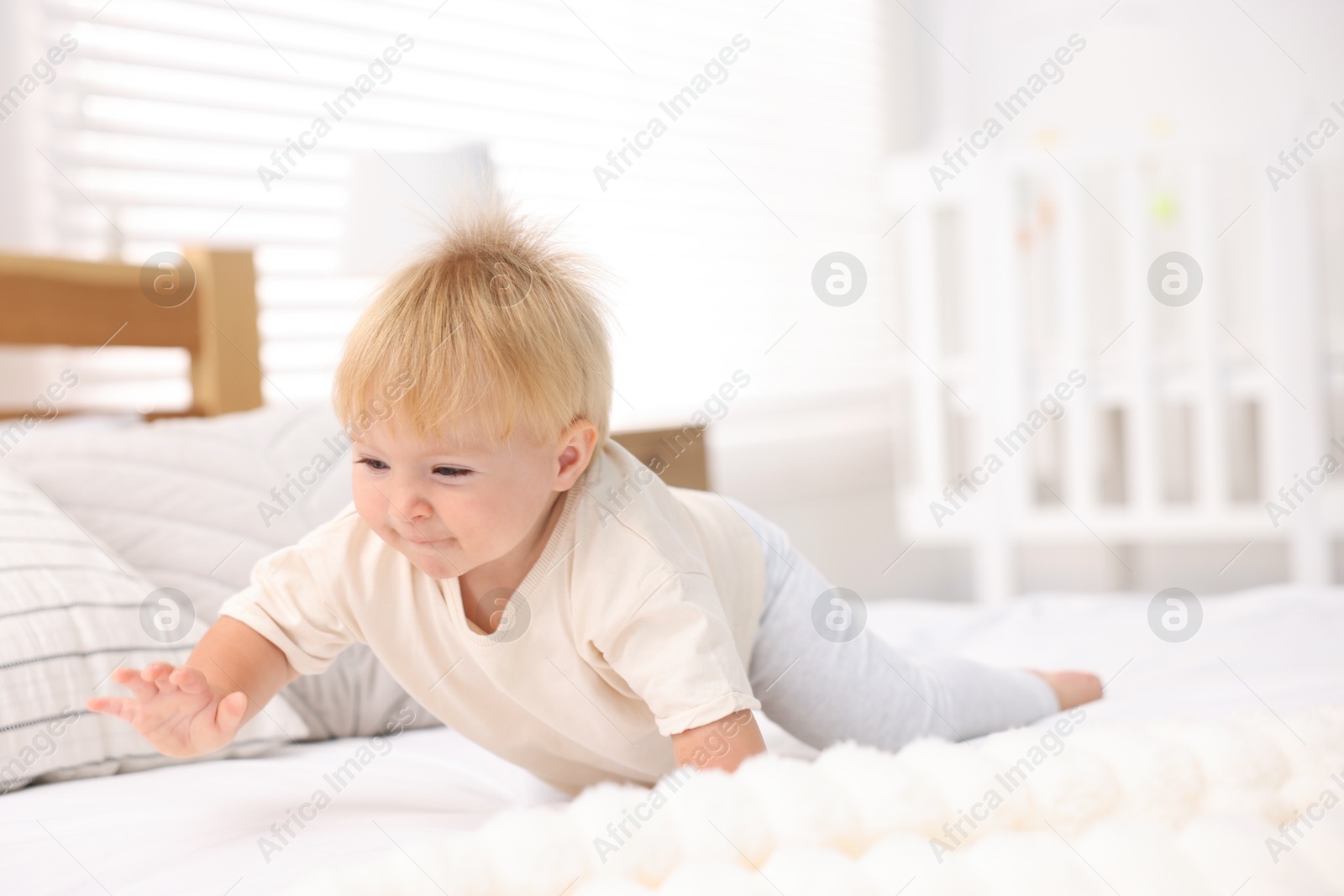Cute little baby on bed in room Photo of Cute little baby on bed in room