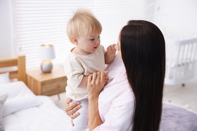 Photo of Mother and her cute little baby in room