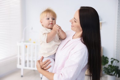 Photo of Mother and her cute little baby in room
