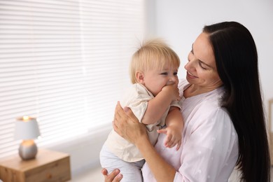 Photo of Mother and her cute little baby in room, space for text