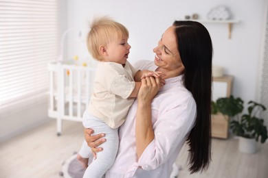 Photo of Mother and her cute little baby in room