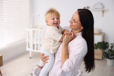 Photo of Mother and her cute little baby in room