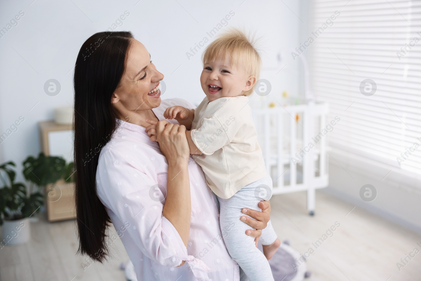 Mother and her cute little baby in room Photo of Mother and her cute little baby in room