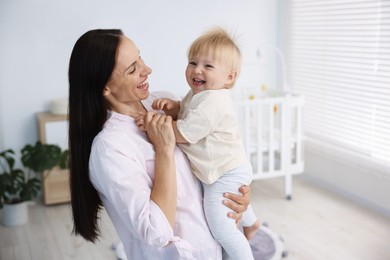 Photo of Mother and her cute little baby in room