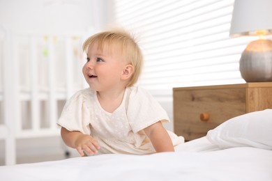 Photo of Cute little baby on bed in room