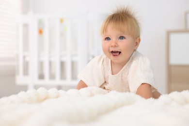 Photo of Cute little baby on bed in room, space for text