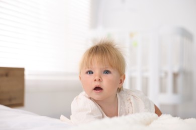 Photo of Cute little baby on bed in room