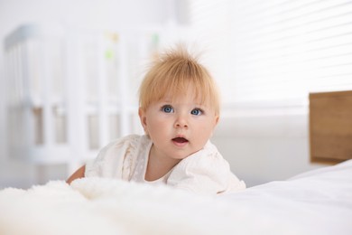 Photo of Cute little baby on bed in room